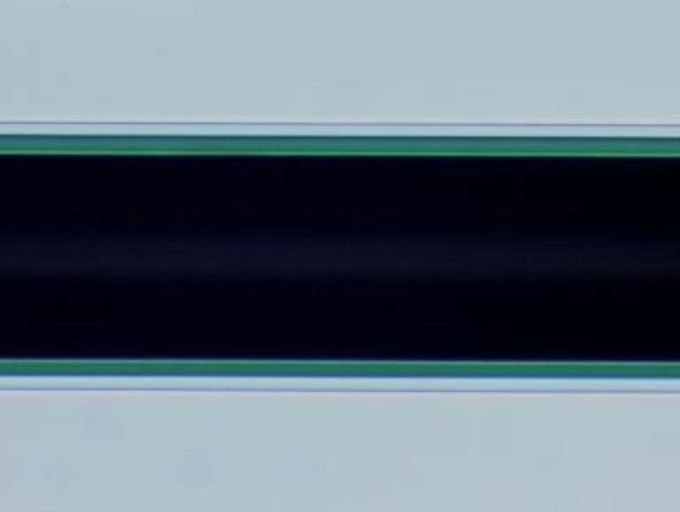 Transmitted light photo of selfbonding wire 0.09 mm AB15 green V=200 X Transmitted light photo of selfbonding wire 0.09 mm AB15 green V=200 X